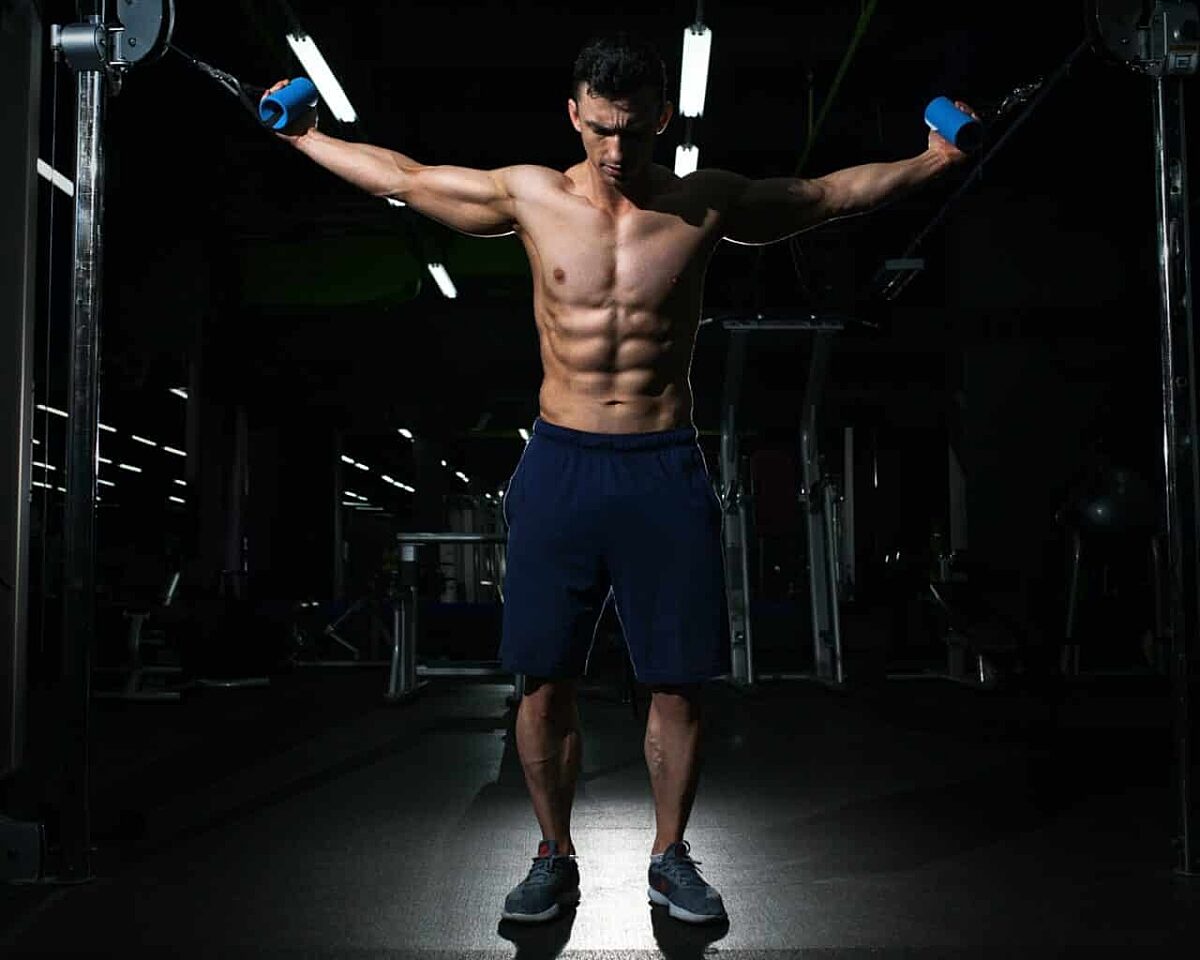 Ein Muskolöser Mann der am Seilzug trainiert